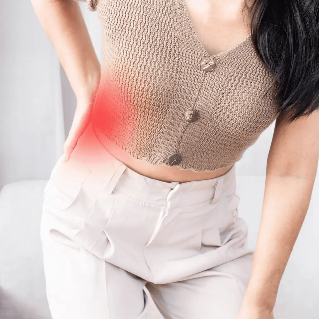 person holding their lower back, with a line tracing pain down the leg